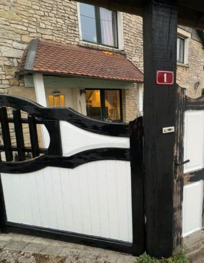 Après rénovation : Portail en bois restauré avec peinture noire et blanche par SNMultiservices
