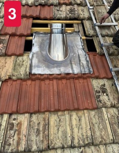 Base de cheminée en cours de rénovation sur un toit, montrant la structure et les briques